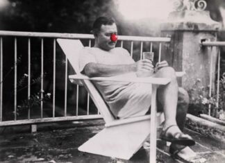 a man sitting in a chair with a glass of wine